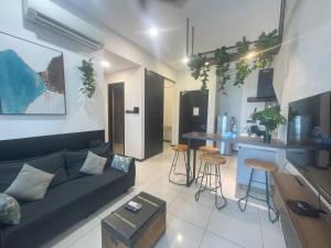 a living room with a couch and a kitchen at Opus Residences KL by SA in Kuala Lumpur