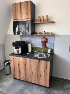 a kitchen counter with a sink and a microwave at DH Hotel Deutsches Haus - Ihr neuer Rückzugsort im Herzen von Mittweida, digitales Hotel im historischen Gebäude in Mittweida