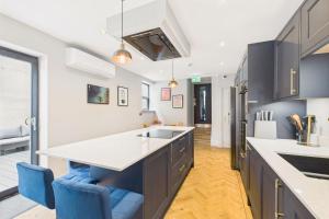 eine Küche mit einer großen Insel und blauen Stühlen in der Unterkunft Host & Stay - Bellevue Luxe in Redcar