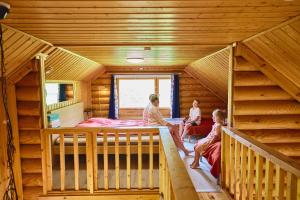 three people sitting in a room in a log cabin at Serena Villas in Espoo