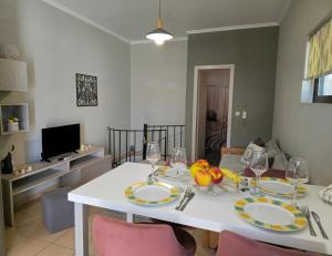 a dining room with a white table with plates and wine glasses at Emily's House in Kissamos +9 photos