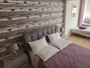 a bedroom with a bed and a wooden wall at Emily's House in Kissamos