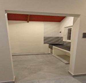 an empty room with a kitchen with a counter at Rv Resorts Yercaud in Yercaud