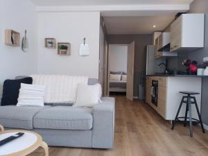 a living room with a couch and a kitchen at Vkls Appartement 1 in Languidic