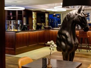 a statue of a horse on a table in a restaurant at Aparthotel Adagio Frankfurt City Messe in Frankfurt/Main
