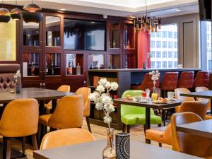a restaurant with tables and chairs at Aparthotel Adagio Frankfurt City Messe in Frankfurt/Main