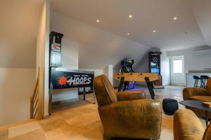 ein Wohnzimmer mit Fernseher und Tisch und Stühlen in der Unterkunft Domaine le Saint Georges in Catteville