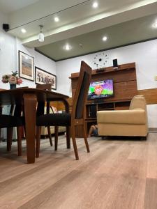 a dining room with a table and a tv at 3BR 70sqm Free internet, Penthouse unit in Ermita, Manila near US Embassy in Manila