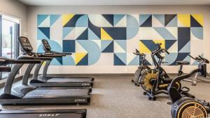 a gym with three exercise bikes and a mural at CozySuites AYR in Indianapolis