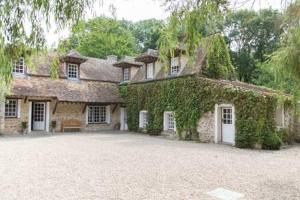 a large stone house with ivy growing on it at Charmant manoir Sud de Paris in Saint-Sauveur-sur-École