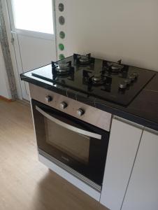 a black stove top oven in a kitchen at O cantinho d'abelheira  +6 photos