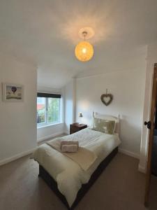 a bedroom with a large bed with a light at Beach Hill House - Rhos on Sea in Colwyn Bay