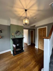 a living room with a fireplace and a chandelier at Beach Hill House - Rhos on Sea in Colwyn Bay