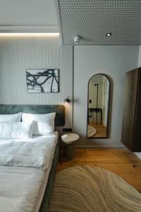 a bedroom with a bed and a large mirror at Conlon House Lower East Side in Munich