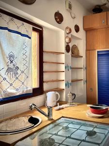 una cucina con bancone, lavandino e finestra di Vicinissima alla spiaggia della Pelosa a Stintino