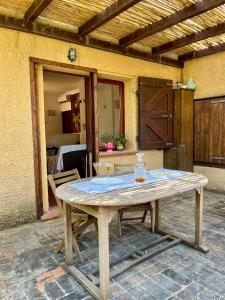 un tavolo di legno con due bicchieri sopra un patio di Vicinissima alla spiaggia della Pelosa a Stintino