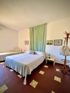 una camera da letto con un letto e una tenda verde di Vicinissima alla spiaggia della Pelosa a Stintino