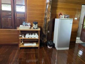 a kitchen with a refrigerator next to a wooden wall at Gavin House in Ban Nong Chaeng