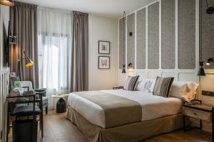 a hotel room with a large bed and a desk at Hotel Barcelona Catedral 4 Sup in Barcelona