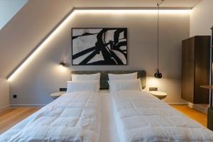 a bedroom with a large bed with white sheets at Conlon House Lower East Side in Munich