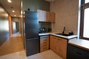 a kitchen with a stainless steel refrigerator and wooden cabinets at Apartamenty Rynek 13 in Grudziądz