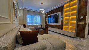 a living room with a couch and a tv at Tanger City Center Luxury 2BR AC WiFi Garage in Tangier
