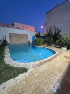 ein Swimmingpool in einem Hinterhof bei Nacht in der Unterkunft cottage with swimming pool in Raoued