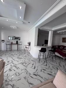 ein Raum mit Marmorboden mit Stühlen und einer Theke in der Unterkunft cottage with swimming pool in Raoued