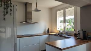 a kitchen with white cabinets and a sink and a window at Charming apartment Côte Bleue in Ensuès-la-Redonne