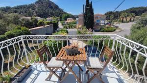 a table and chairs on a balcony with a view at Charming apartment Côte Bleue in Ensuès-la-Redonne