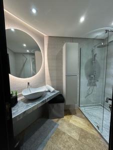 a bathroom with a sink and a glass shower at Modern 2BR Apartment Tangier Center with Air Conditioning and WiFi in Tangier