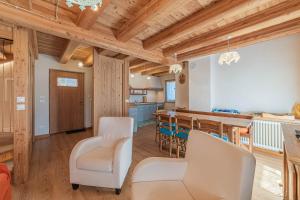 Il comprend une cuisine et une salle à manger avec des plafonds en bois. dans l'établissement Chalet Dolomites Heart, à Feder