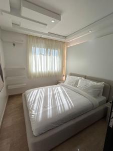 a large white bed in a bedroom with a window at Modern 2BR Apartment Tangier Center with Air Conditioning and WiFi in Tangier