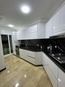 a kitchen with white cabinets and a black counter top at Modern 2BR Apartment Tangier Center with Air Conditioning and WiFi in Tangier +13 photos