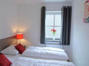 a bedroom with two beds and a window with a vase of flowers at Haus Waldblick in Winterberg