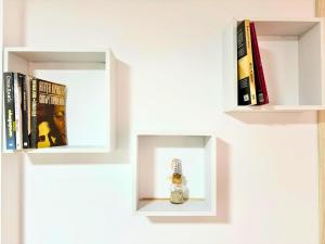 ein weißes Bücherregal mit Büchern und einer Puppe darin in der Unterkunft City Charm Apartments 1A in Warna