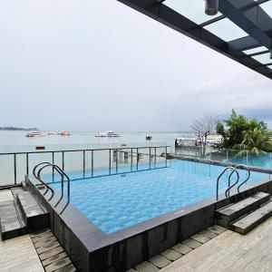 a swimming pool with a view of the water at Cozy Apartment with Sea View - One Residence in Pulau Sembakau Kecil