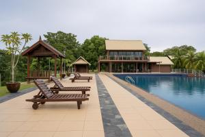 einen Pool mit Bänken neben einem Gebäude in der Unterkunft The Langit Duyong Marina Resort in Kuala Terengganu