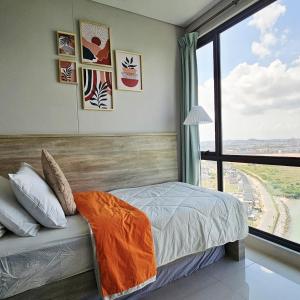 a bedroom with a bed and a large window at Cozy Apartment with Sea View - One Residence in Pulau Sembakau Kecil