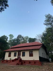 a small white house with a red roof at Dreamland Vintage Homestay in Jambur +2 photos