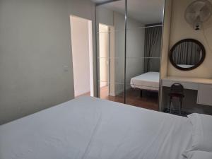 Un dormitorio con una cama blanca y un espejo. en Los Molinos 735, en Maspalomas 14 fotos más
