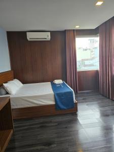 a bedroom with a bed with a blue blanket on it at Blue Luxury Hotel & Spa in Da Nang