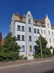 Un gran edificio blanco al costado de una calle. en Privatzimmer in Altenburg, en Altemburgo