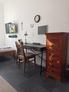 Un dormitorio con un escritorio con una silla y una cómoda. en Privatzimmer in Altenburg, en Altemburgo