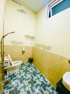 a bathroom with a toilet and a sink at Khách Sạn Bình Nguyên Đà Lạt in Da Lat