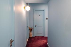 a hallway with a white door and a vase with a plant at HB Freeze Inn in Tbilisi City +12 photos