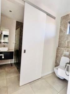 a white bathroom with a toilet and a sink at The Aurelian Apartment in Johannesburg +24 photos