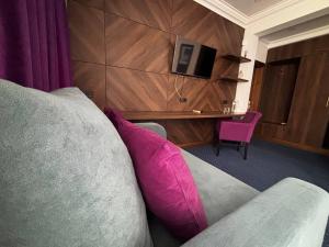 a living room with a couch with a pink pillow at Hotel Fridman in Odesa +37 photos