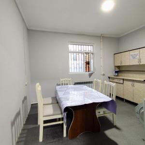a kitchen with a table and chairs in a room at Megahostel in Osh