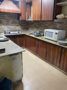 ラーワルピンディーにあるFully Furnished House available for Rent on Daily and weekly basisのキッチン(木製キャビネット、電子レンジ付)